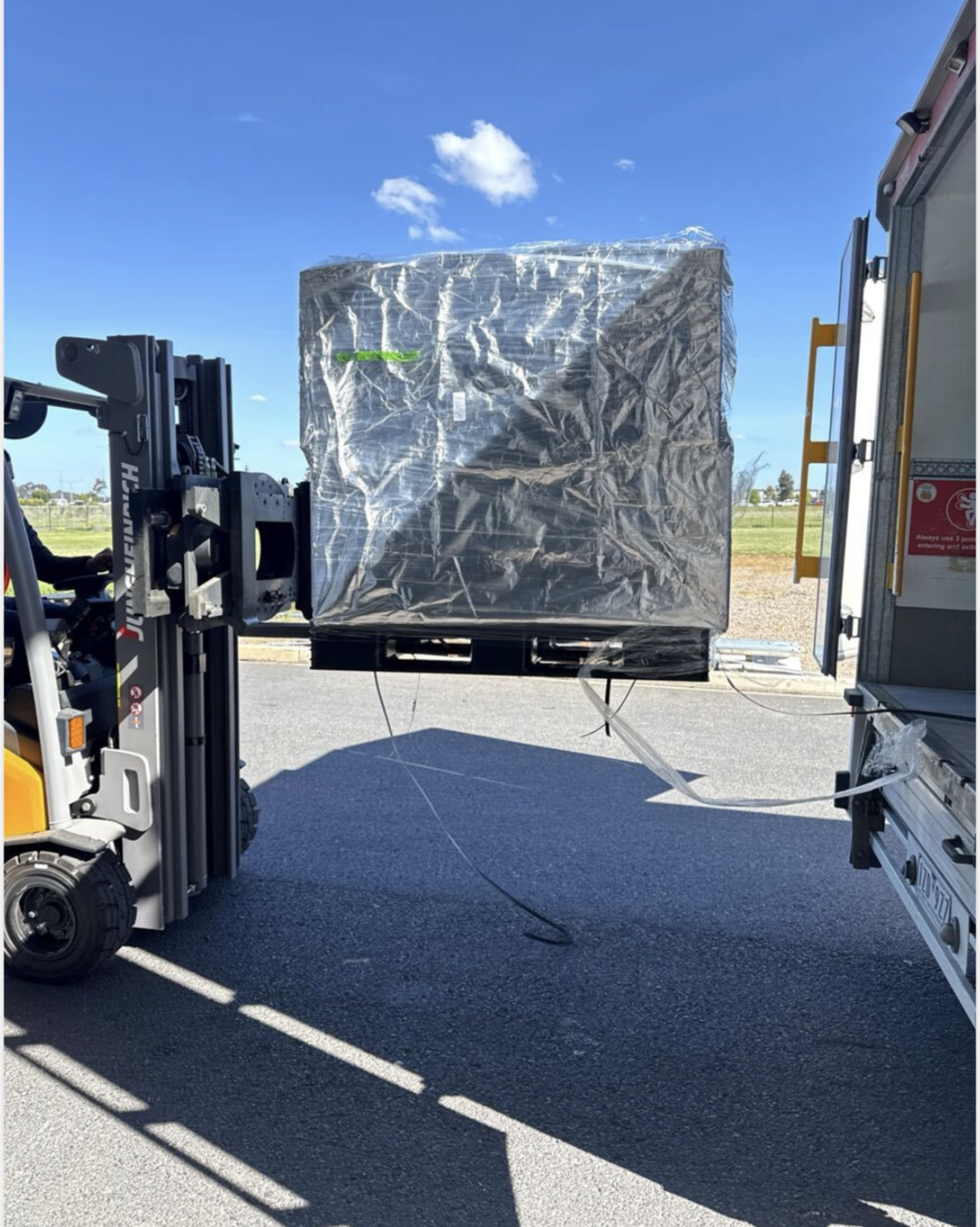 Forklift loading shrink-wrapped medicinal cannabis pallet onto refrigerated delivery vehicle — GLG wholesale distribution